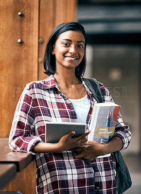 Buy stock photo Cropped shot of a young female student holding a tablet and textbooks outside on campus