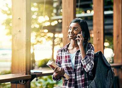 Buy stock photo Shot of a young female student on a call outside on campus