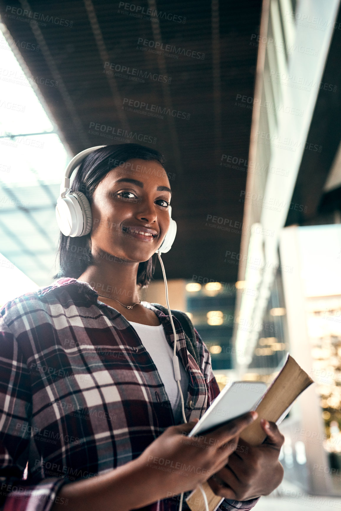 Buy stock photo Cropped shot of a young female student listening to music outside on campus