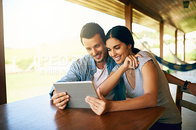 Buy stock photo Cropped shot of an attractive young married couple using a tablet together at home