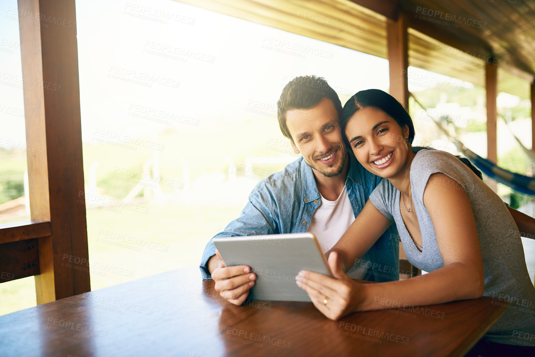 Buy stock photo Cropped shot of an attractive young married couple using a tablet together at home