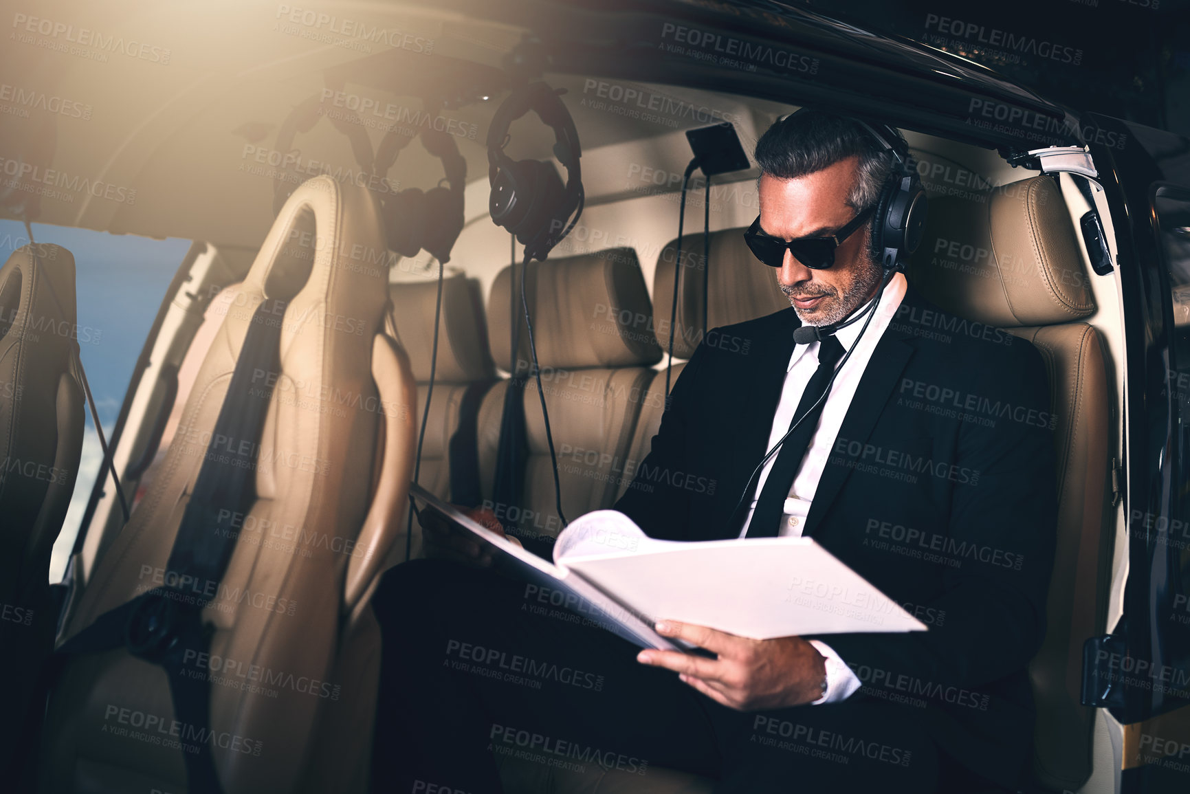 Buy stock photo Man, pilot and business with paperwork for travel, proposal or international trip for job or career opportunity on flight. Businessman with documents or headphones on airplane for private journey