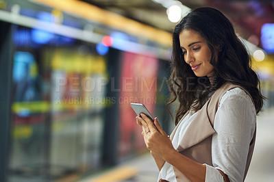 Buy stock photo Cropped shot of a young attractive woman using a cellphone while commuting with the train