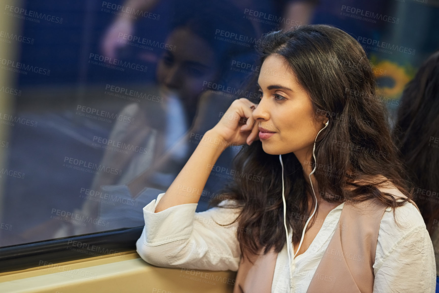 Buy stock photo Cropped shot of a young attractive woman listening to music while commuting with the train