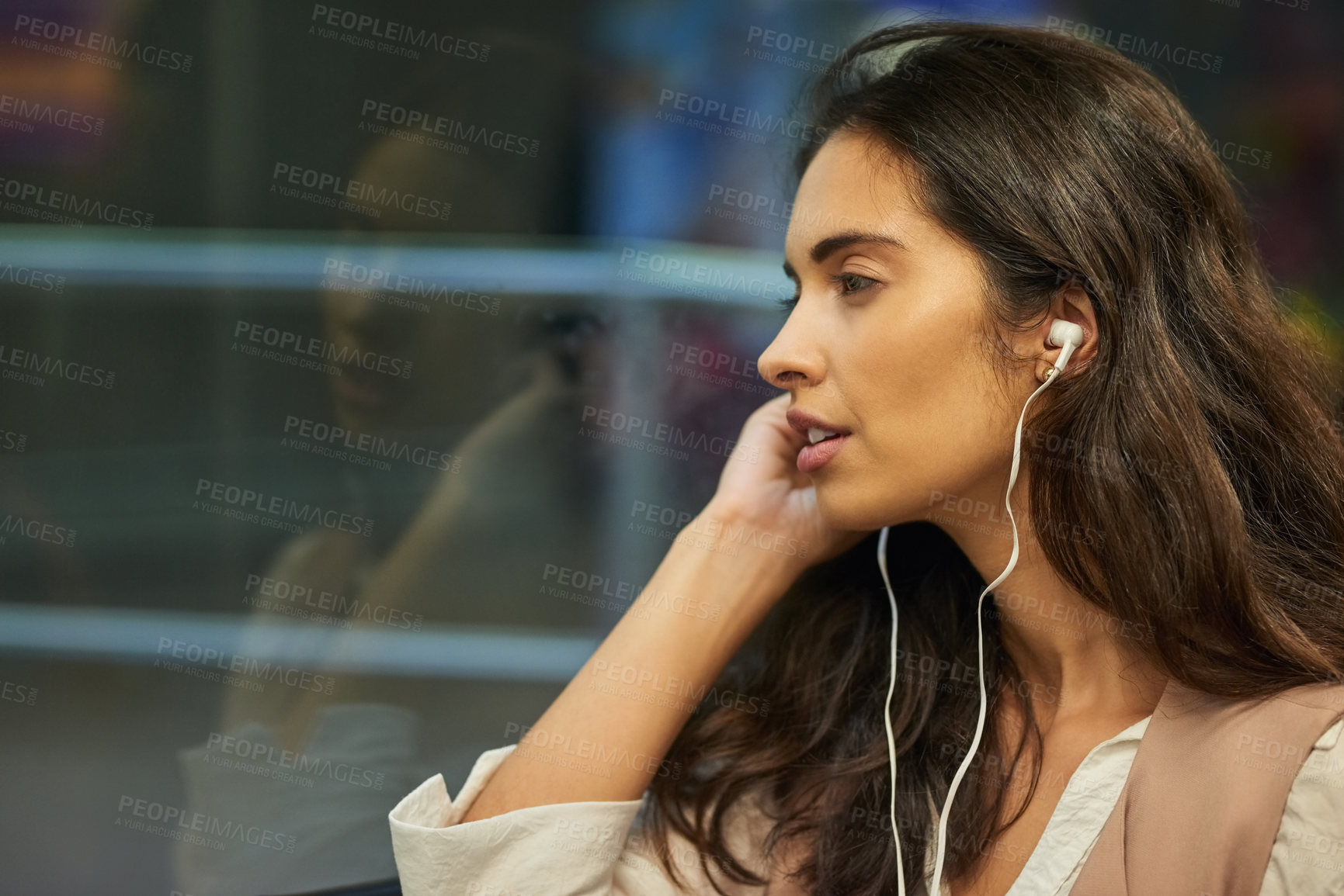 Buy stock photo Cropped shot of a young attractive woman listening to music while commuting with the train