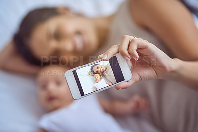 Buy stock photo Shot of a young woman taking selfies with her adorable baby boy at home