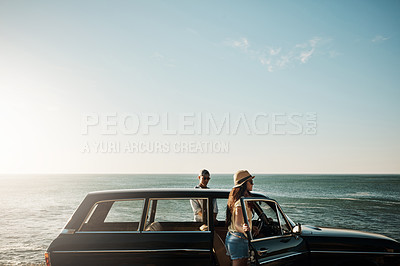 Buy stock photo Shot of a young couple enjoying a road trip along the coast