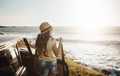 Buy stock photo Shot of a young woman enjoying a road trip along the coast