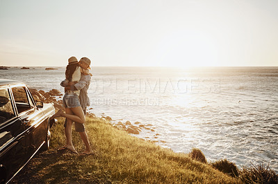 Buy stock photo Shot of an affectionate young couple enjoying a road trip along the coast