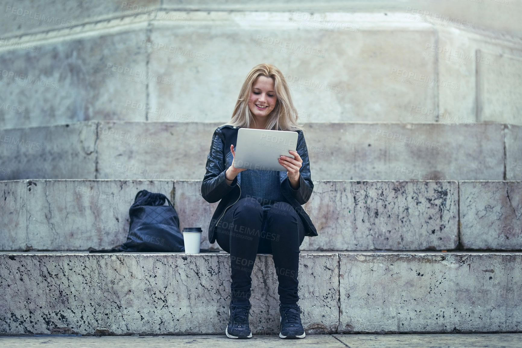Buy stock photo Shot of an attractive woman using a digital tablet in the city