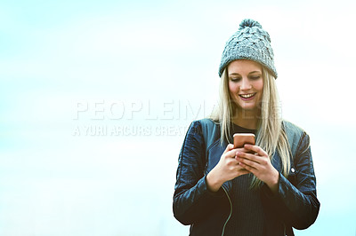Buy stock photo Shot of an attractive young woman using a mobile phone outdoors