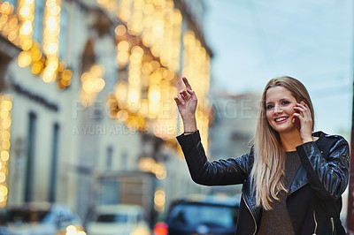 Buy stock photo Shot of an attractive woman using a mobile phone while calling a cab in the city