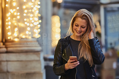 Buy stock photo Woman, smile and typing with phone in city for text message, social media scroll or checking notifications. Girl, smartphone or person with communication outdoor at night with mobile chat or browsing