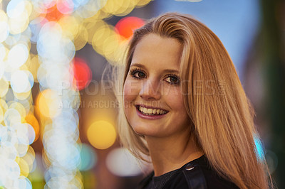 Buy stock photo Shot of a confident young woman out and about in the city at night