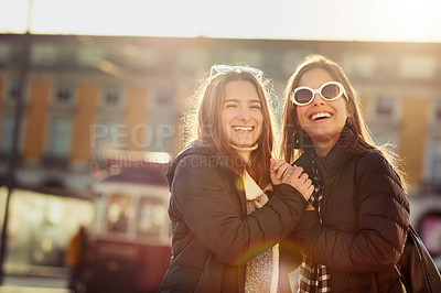 Buy stock photo Cropped shot of two attractive young women spending a day in the city