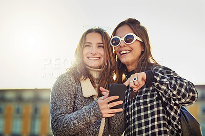 Buy stock photo Cropped shot of two attractive young women spending a day in the city