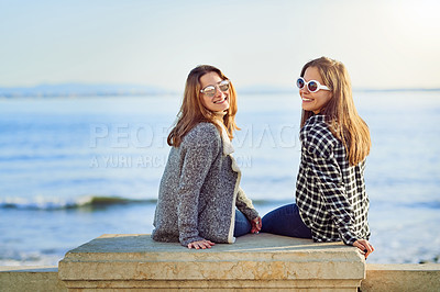 Buy stock photo Rearview portrait of two attractive young women spending a day by the ocean