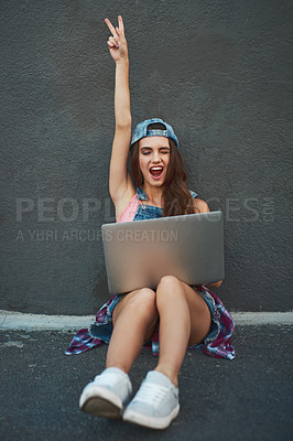 Buy stock photo Shot of a cheerful young woman working on a laptop while raising her hand and being seated against a grey background