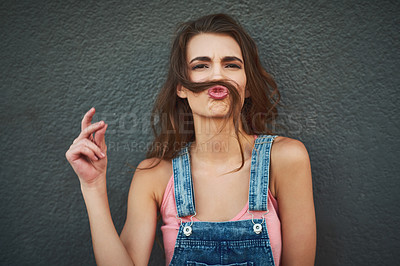 Buy stock photo Woman, portrait and hair mustache with silly, fun and kissing face on gray background wall. Girl, playful smile and relaxing pout with care, happiness and comic joke for funky urban gen z fashion