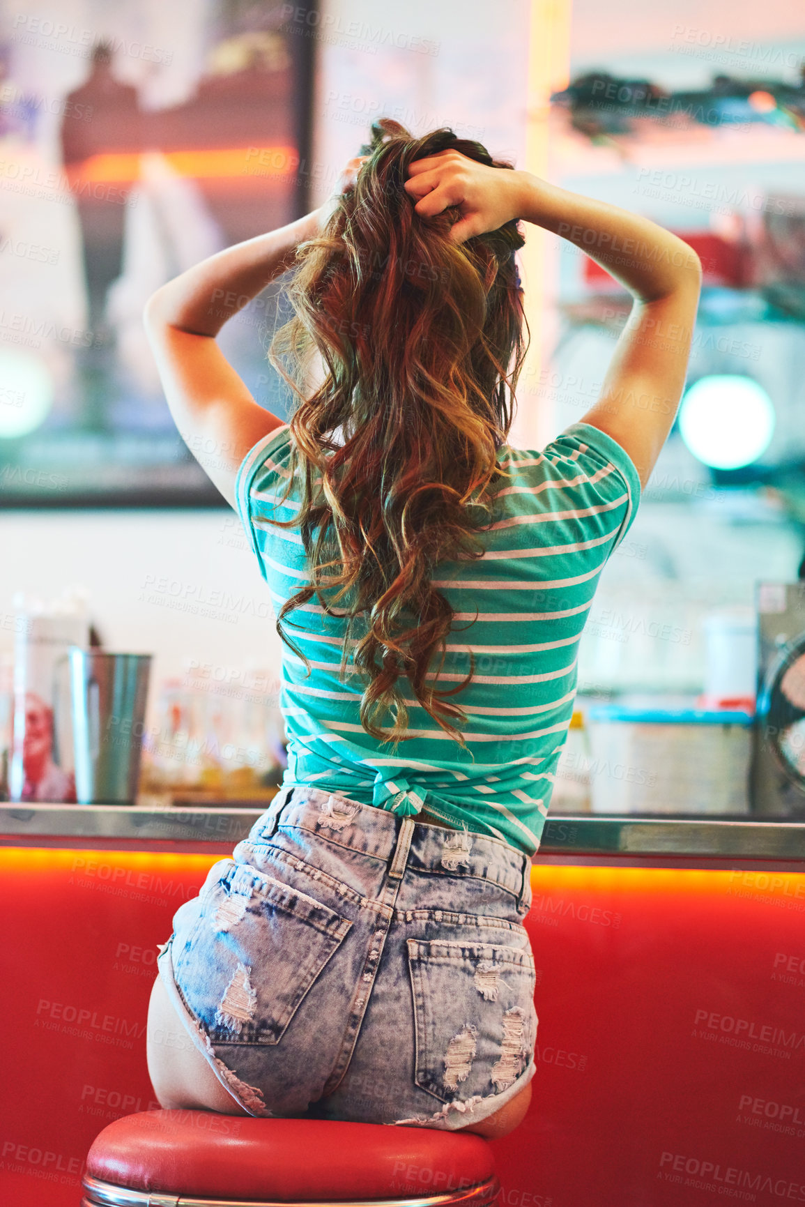 Buy stock photo Rearview shot of an unrecognizable woman holding her hair up in a diner