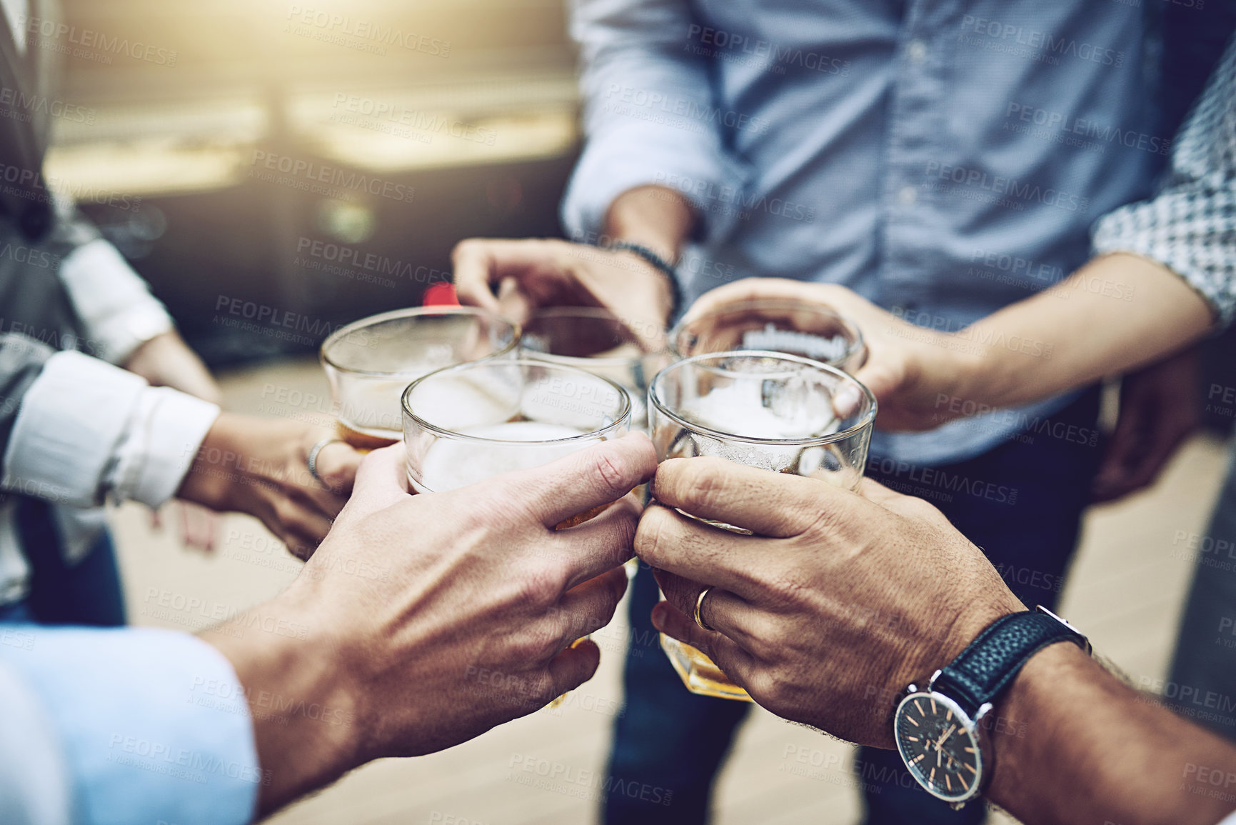 Buy stock photo Shot of a group of unrecognizable work colleagues having a celebratory toast together with beer outside during the day