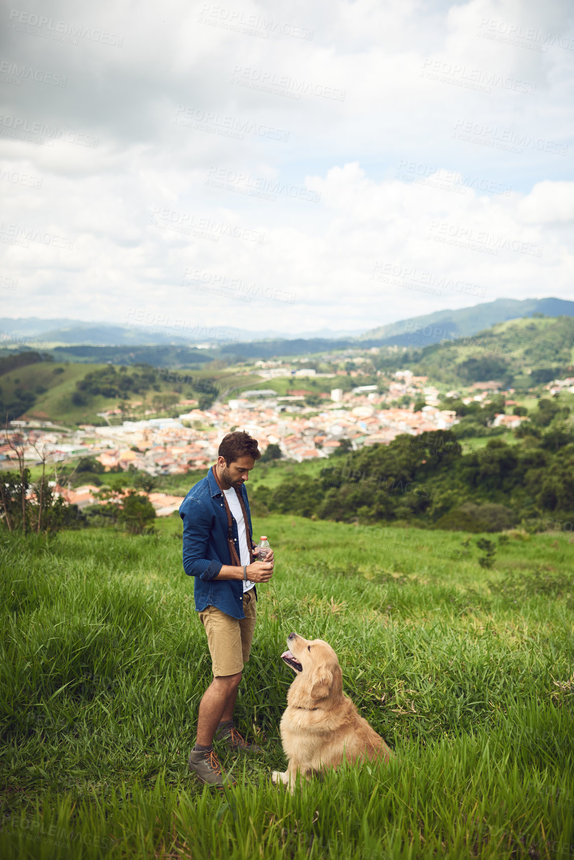 Buy stock photo Full length shot of a handsome young man taking his dog for a walk in the mountains