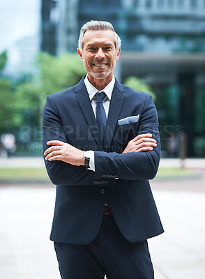 Buy stock photo Portrait of a handsome mature businessman in corporate attire standing with his arms folded outside during the day