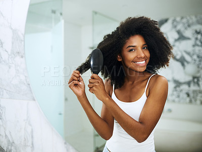 Buy stock photo Portrait of an attractive young woman brushing her hair at home