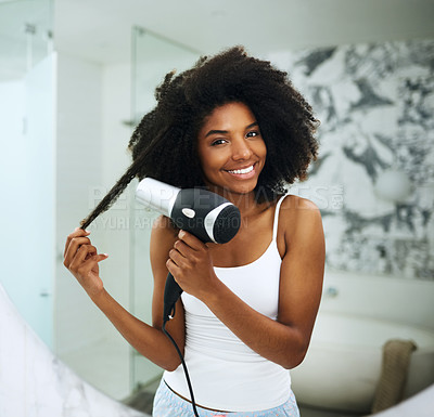 Buy stock photo Portrait of an attractive young woman blowdrying her hair at home