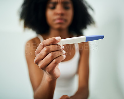 Buy stock photo Shot of a young woman taking a pregnancy test at home