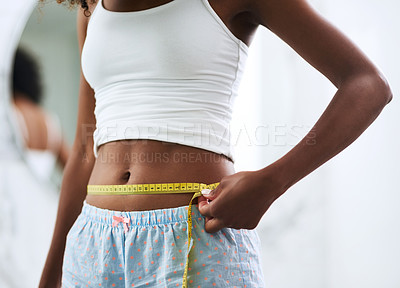 Buy stock photo Closeup shot of an unrecognizable woman measuring her waist