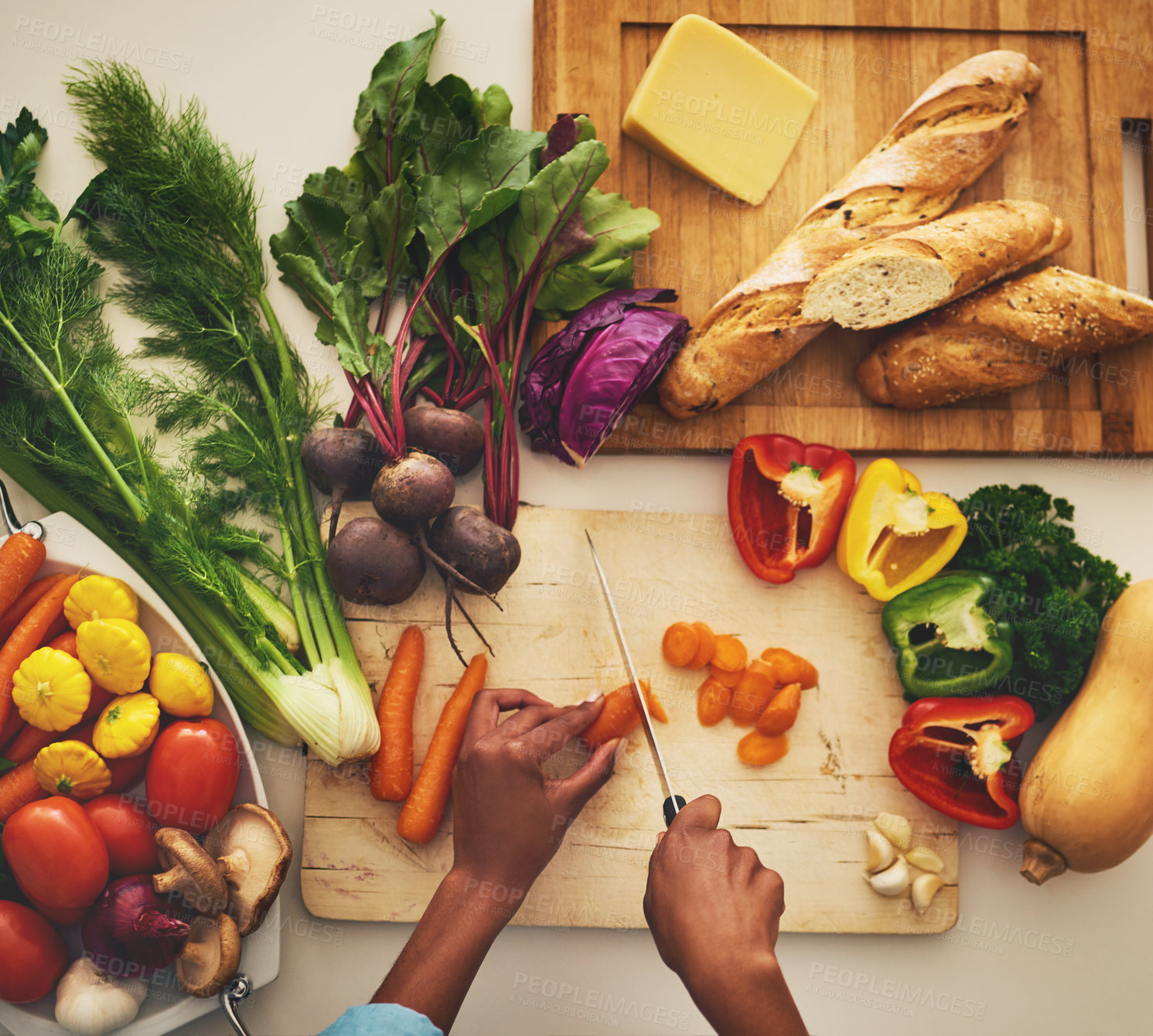 Buy stock photo Shot of an unrecognizable person's hands chopping vegetables on a cutting board in the kitchen at home