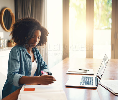 Buy stock photo Shot of an attractive young woman using a laptop while working from home