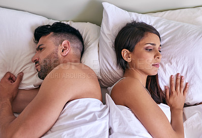 Buy stock photo Cropped shot of a young married couple angry at each other in their bed at home