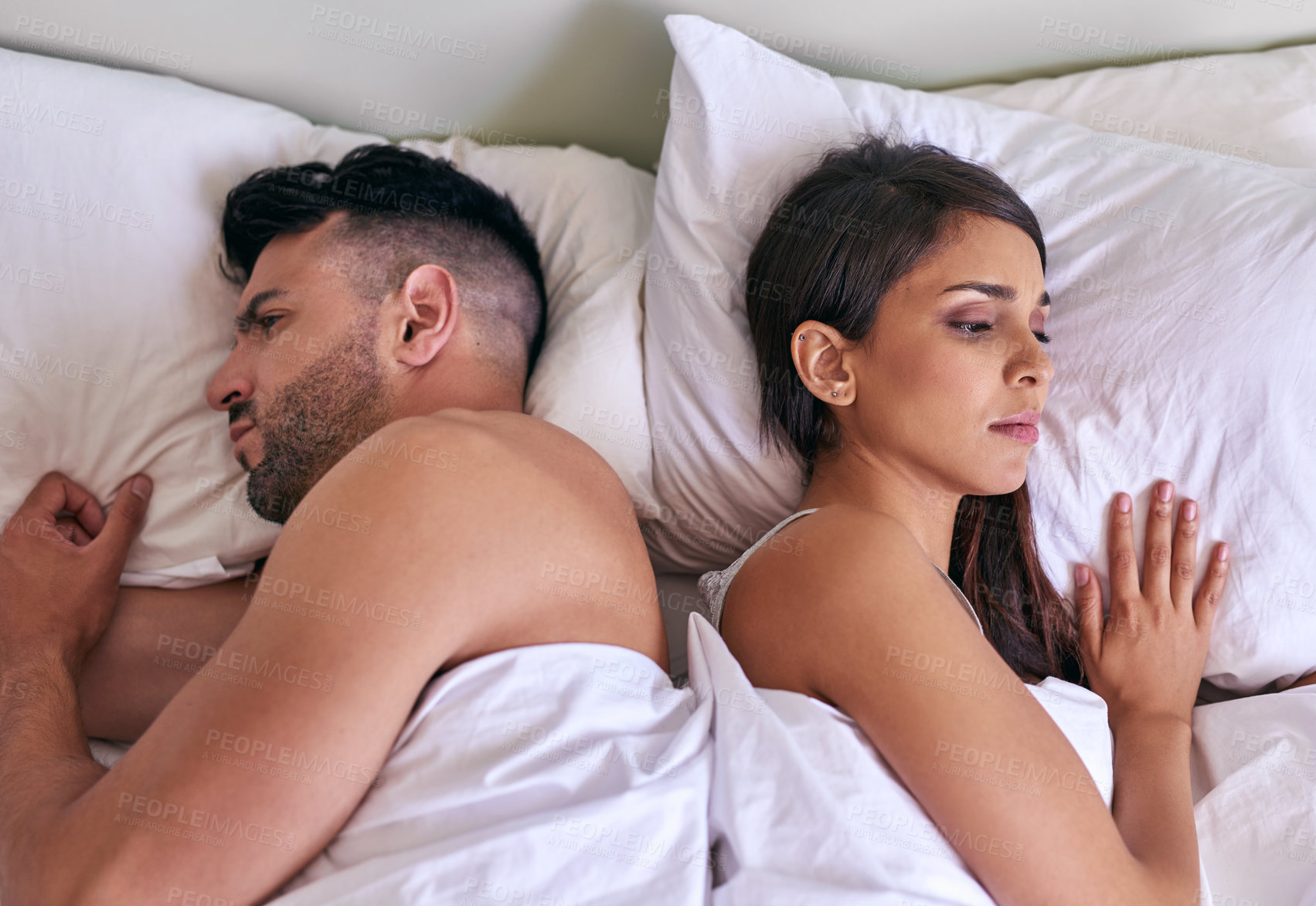 Buy stock photo Cropped shot of a young married couple angry at each other in their bed at home