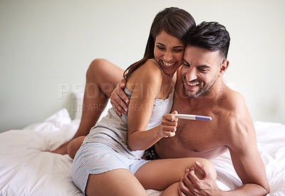 Buy stock photo Cropped shot of a young married couple ecstatic about the results of a pregnancy test in their bedroom at home