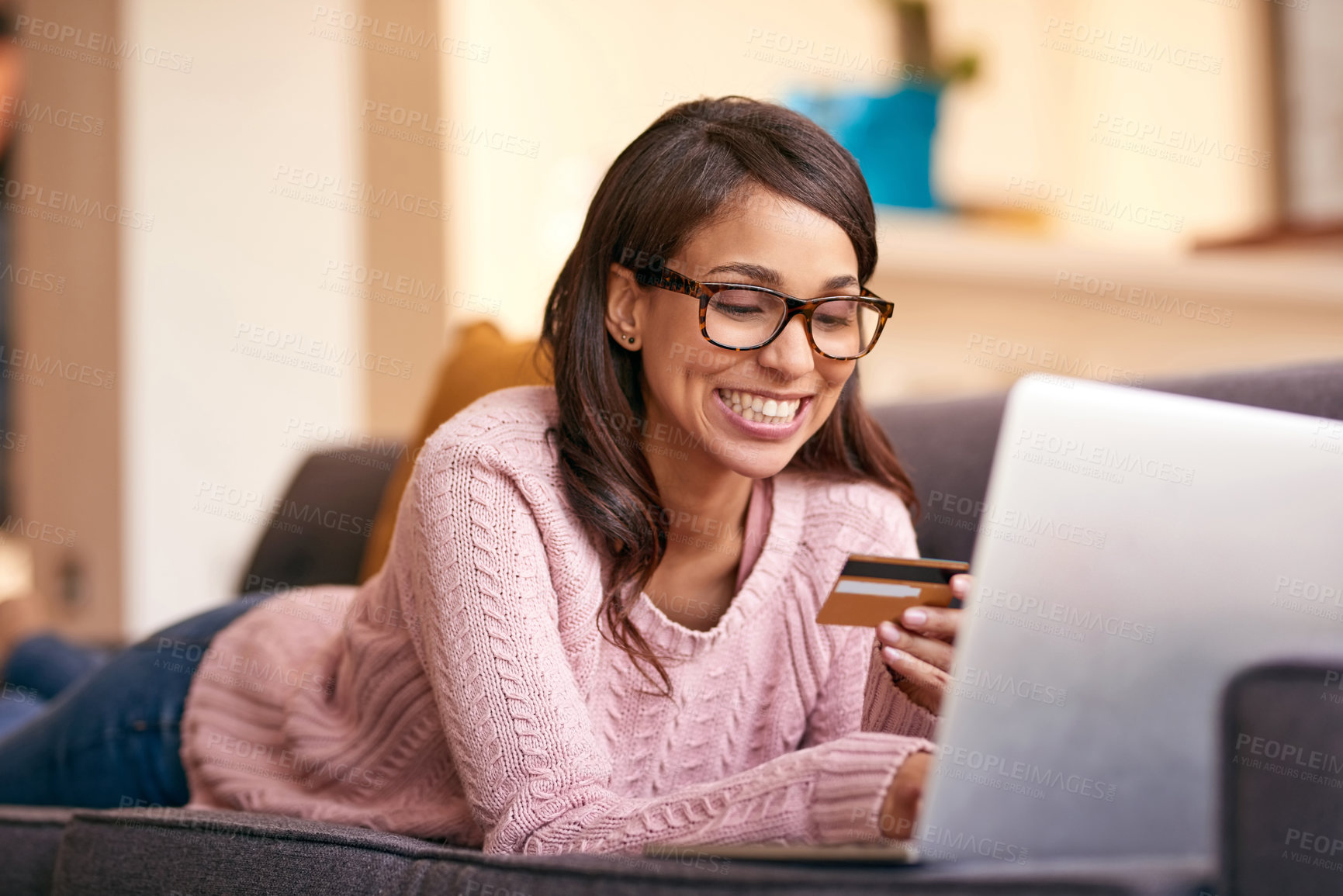 Buy stock photo Debit card, laptop and woman relax in home with happiness for paying bills with debt free lifestyle. Smile, computer and person on sofa with internet banking app to apply for mortgage in apartment.