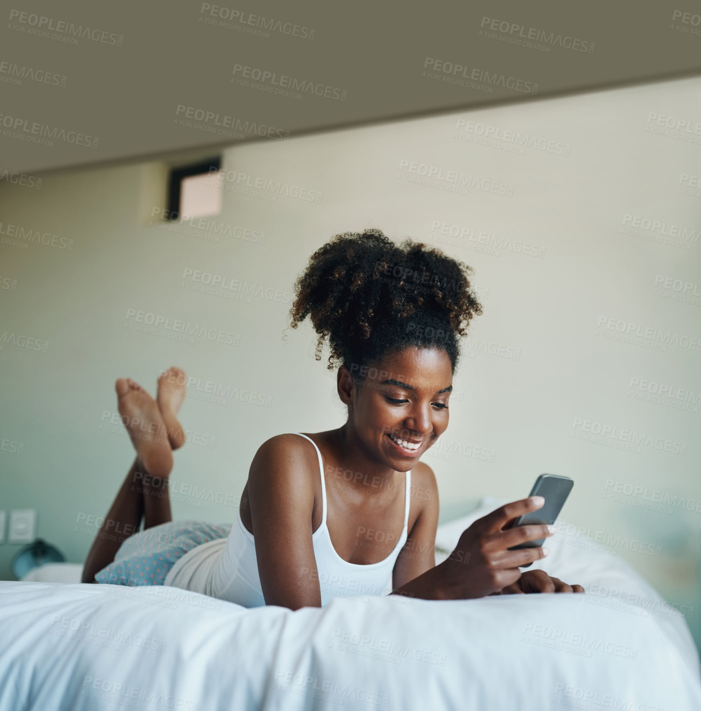 Buy stock photo Black woman, happy and texting with mobile phone for relax, calm and peace in cozy or comfort in home. Female person, smile and morning for waking up in bedroom on tech for health, wellness and rest