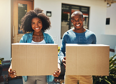 Buy stock photo Portrait of a cheerful young couple holding cardboard boxes together on moving day outside at home during the day