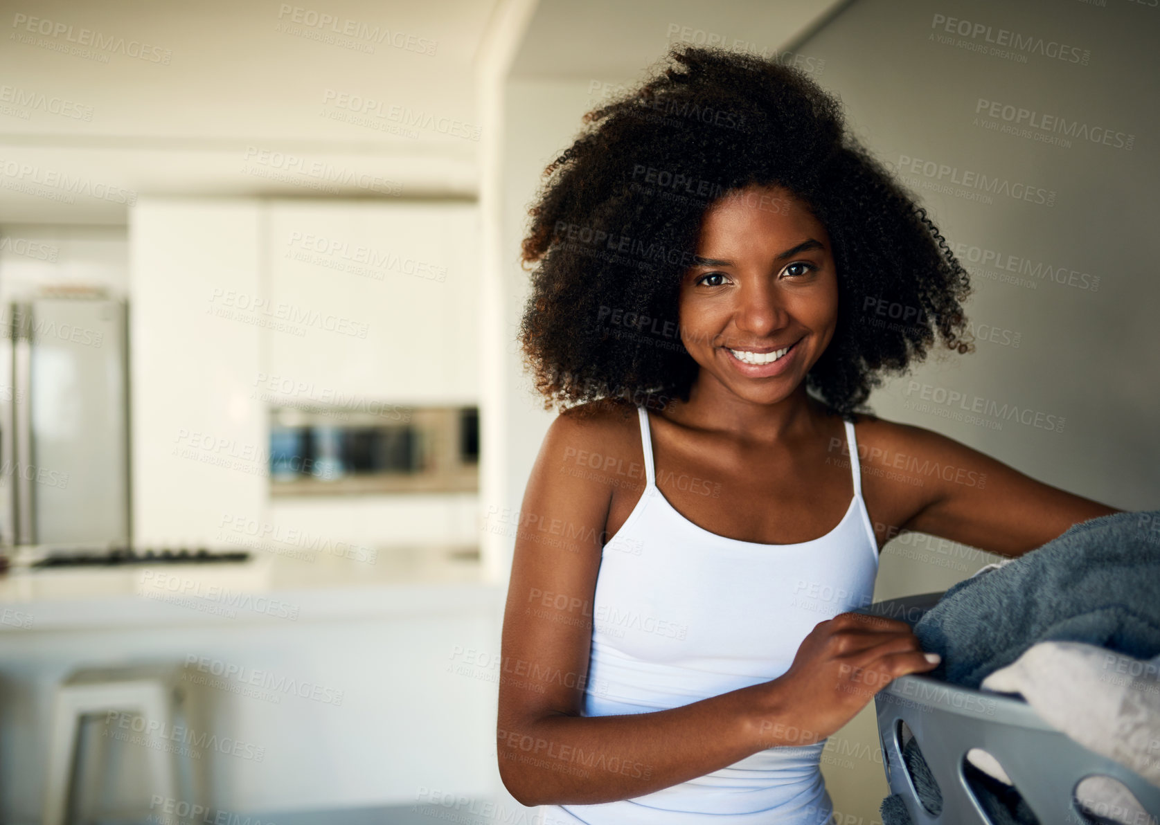 Buy stock photo Cropped shot of an attractive young woman doing the laundry at home