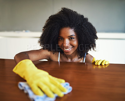Buy stock photo Cropped shot of an attractive young woman wiping the kitchen counter at home
