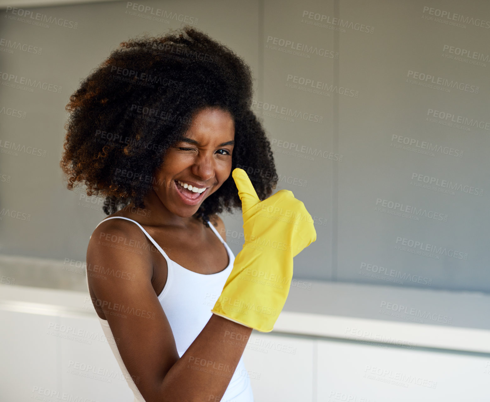 Buy stock photo Cropped shot of an attractive young woman wearing yellow rubber gloves showing a thumbs up at home