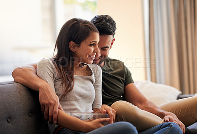 Buy stock photo Shot of an affectionate young couple watching tv together at home
