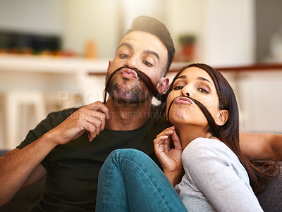 Buy stock photo Shot of a young couple enjoying a silly moment together at home