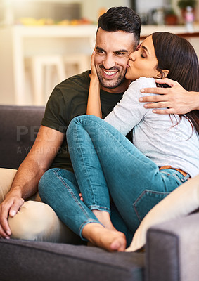 Buy stock photo Shot of an affectionate young couple relaxing at home