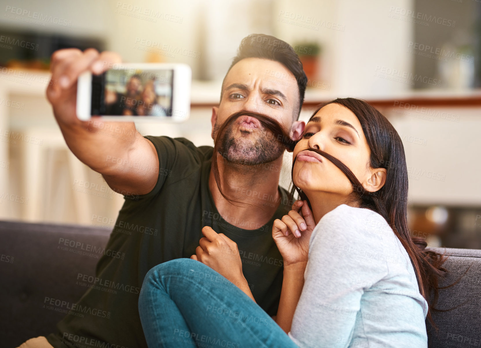 Buy stock photo Shot of a young couple taking selfies together at home