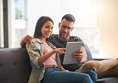 Buy stock photo Shot of a young couple using a digital tablet together at home