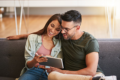 Buy stock photo Shot of a young couple using a digital tablet together at home