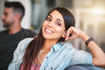Buy stock photo Portrait of a young woman relaxing at home with her husband in the background