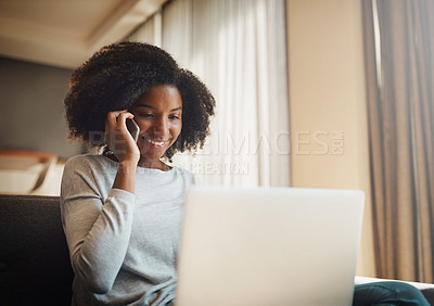 Buy stock photo Shot of an attractive young woman talking on a cellphone while using a laptop at home